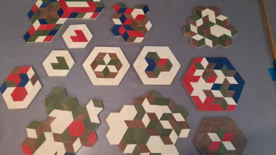 Geometrische Holzpuzzles und Parkett-Muster in verschiedenen Farben auf grauer Oberfläche