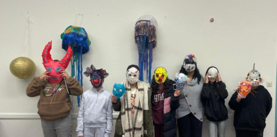 Acht Kinder und Jugendliche präsentieren ihre selbstgemachten Masken in einer Maskenwerkstatt