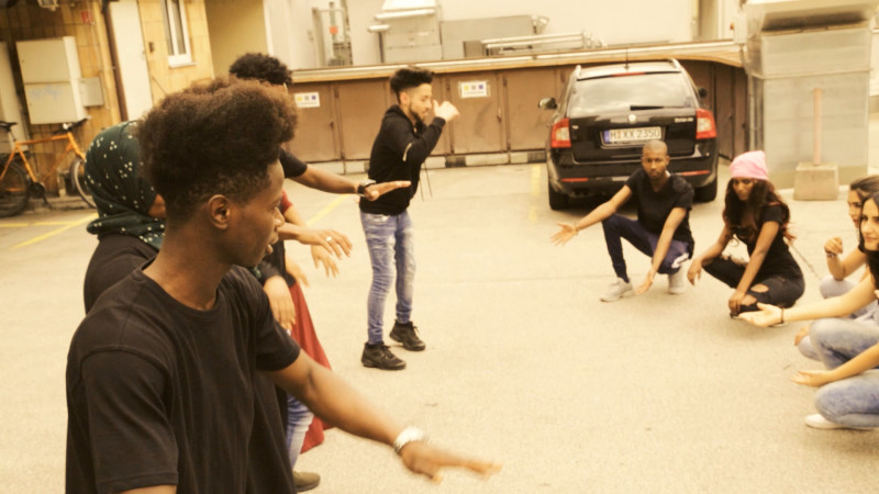 text: >
  Tanzworkshop in einer Garage mit
  mehreren Teilnehmenden, die gemeinsam an
  einer Choreografie arbeiten
decorative: false
source: reviewed