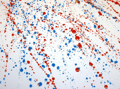Abstraktes Kunstwerk mit roten und blauen Farbspritzern auf weißem Hintergrund