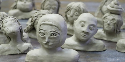 Töpferarbeiten zeigen verschiedene Gesichter und Figuren aus Ton
